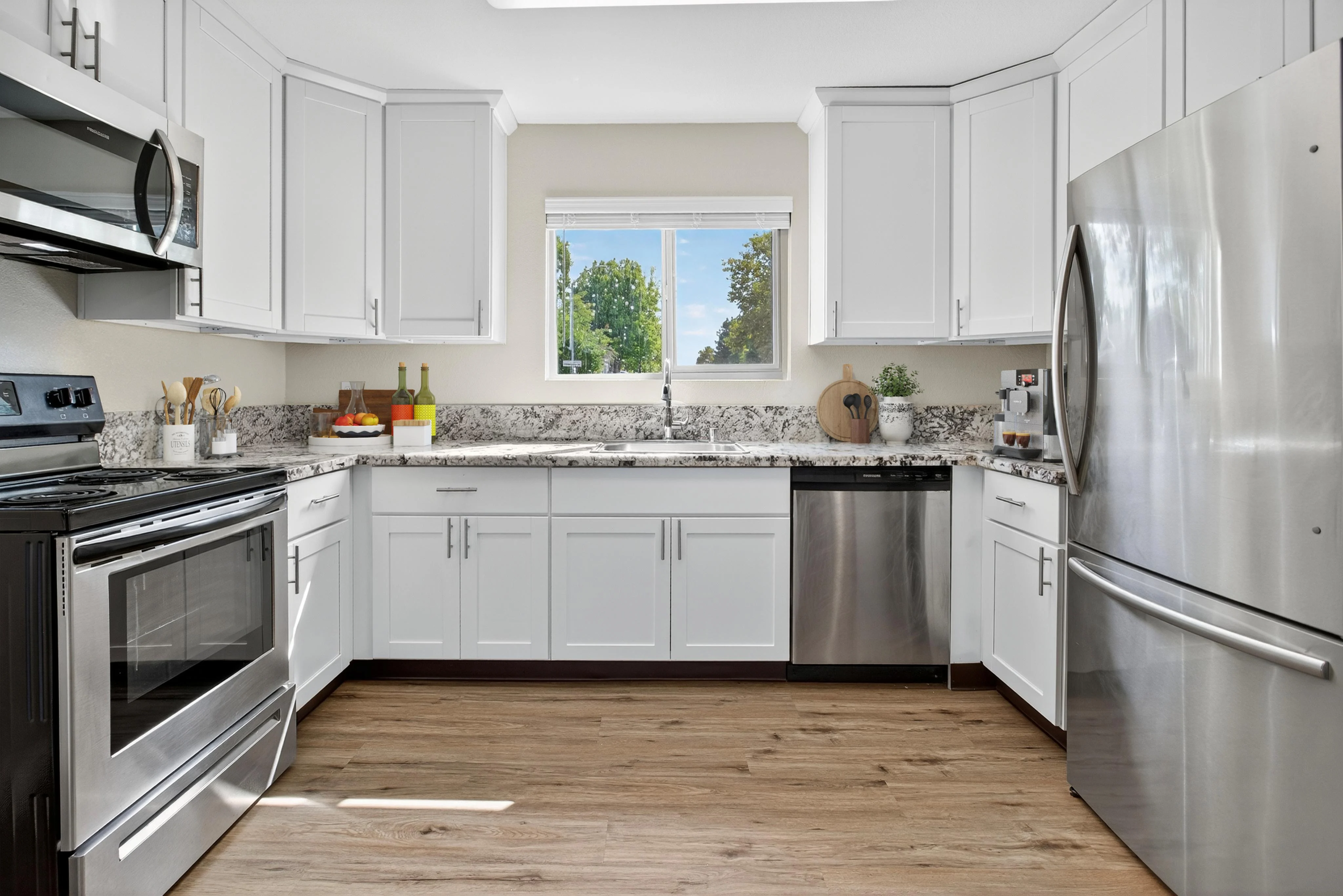 Modern Kitchen Design A modern kitchen featuring white cabinets, stainless steel appliances, and granite countertops with a window for natural light.