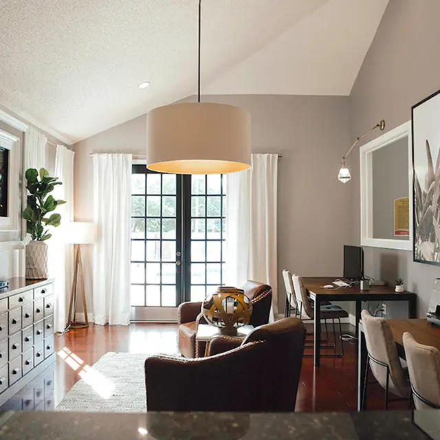 Furnished Living room with chairs, TV on the wall and a pendant lamp hanging from the ceiling. 