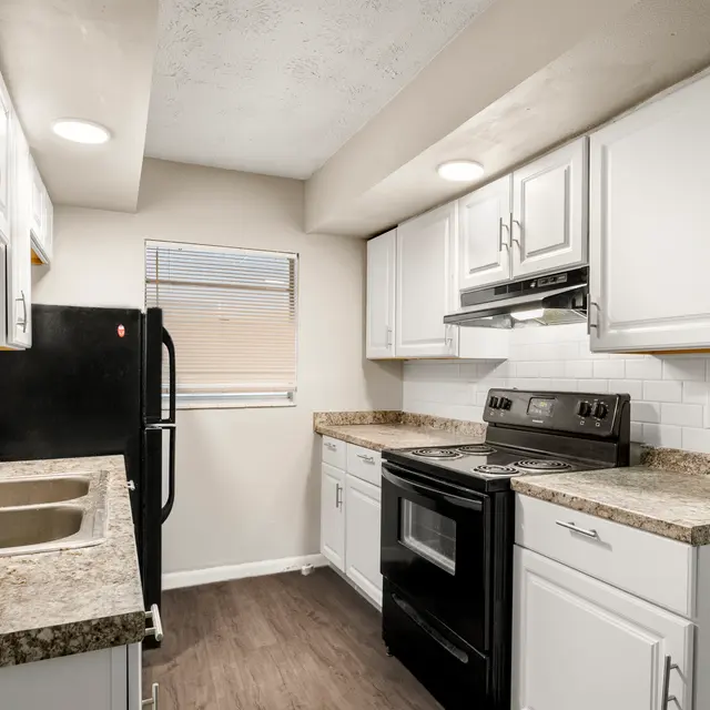 Modern kitchen with granite-style counters, double sink, and subway tile backsplash.
