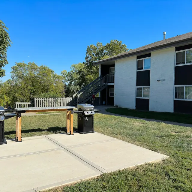 Outdoor Grilling Area Open outdoor grilling area with two grills and an apartment building in the background.