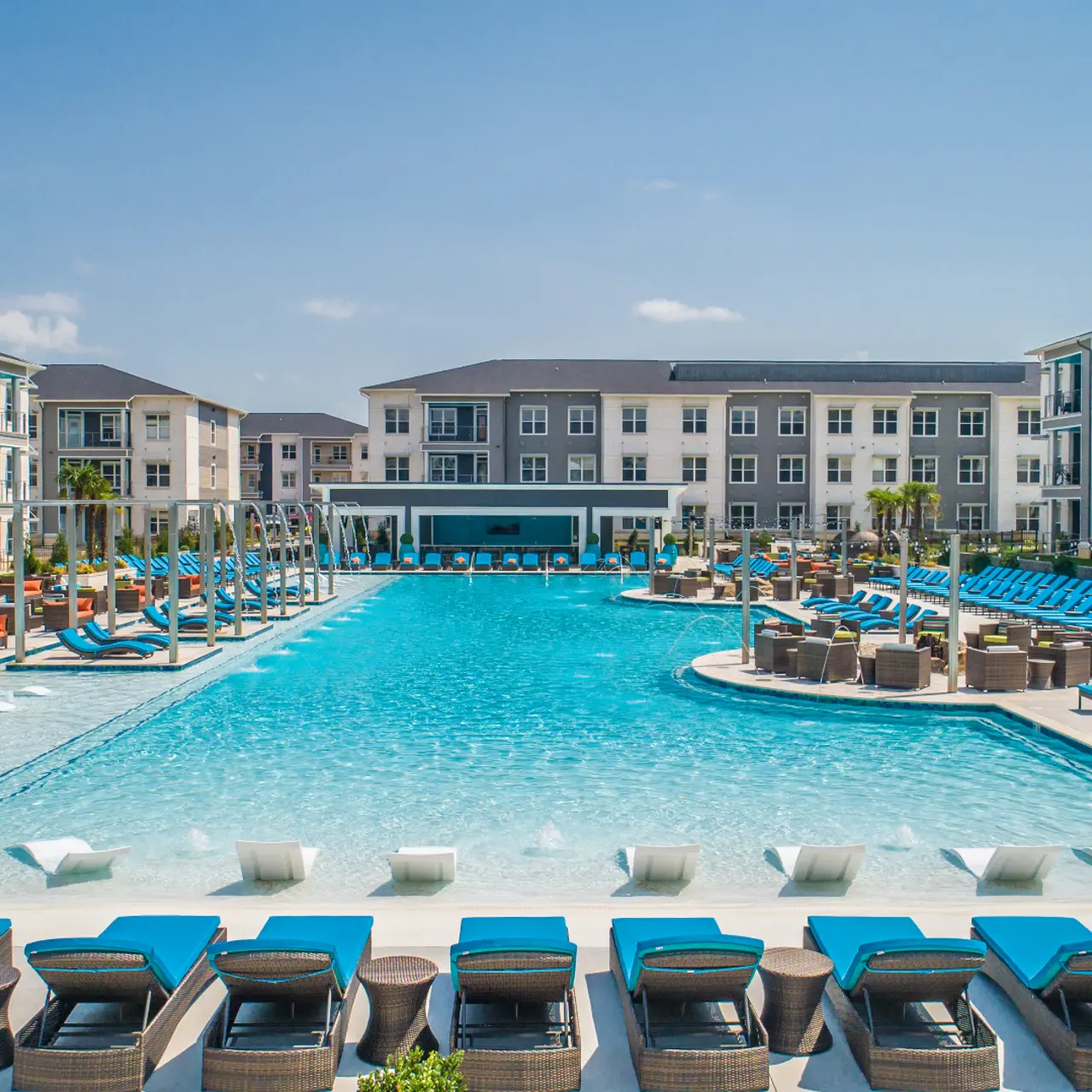 Swimming Pool - The Pointe North Hills Photo of the pool at The Pointe North Hills. It's the largest private residential pool in the state of Arkansas! Features lounge chairs, water loungers, poolside fire pits, grills, and ping pong tables.