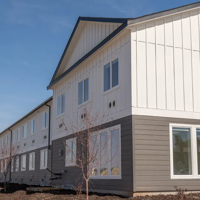 Exterior view of a modern building with a two-tone color scheme and multiple large windows