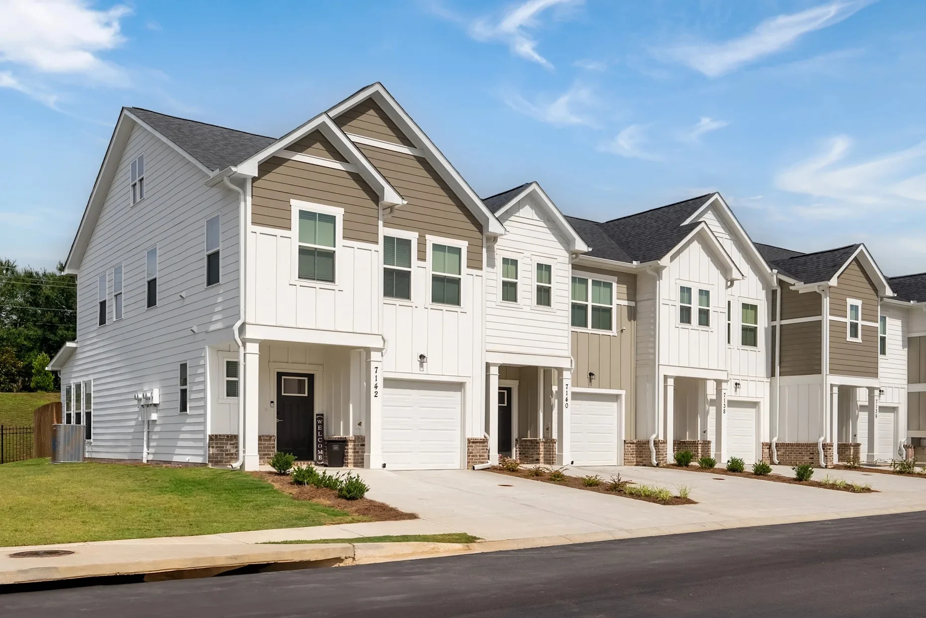 Modern Two-Story Homes Exterior view of a row of modern two-story houses with white siding and garages