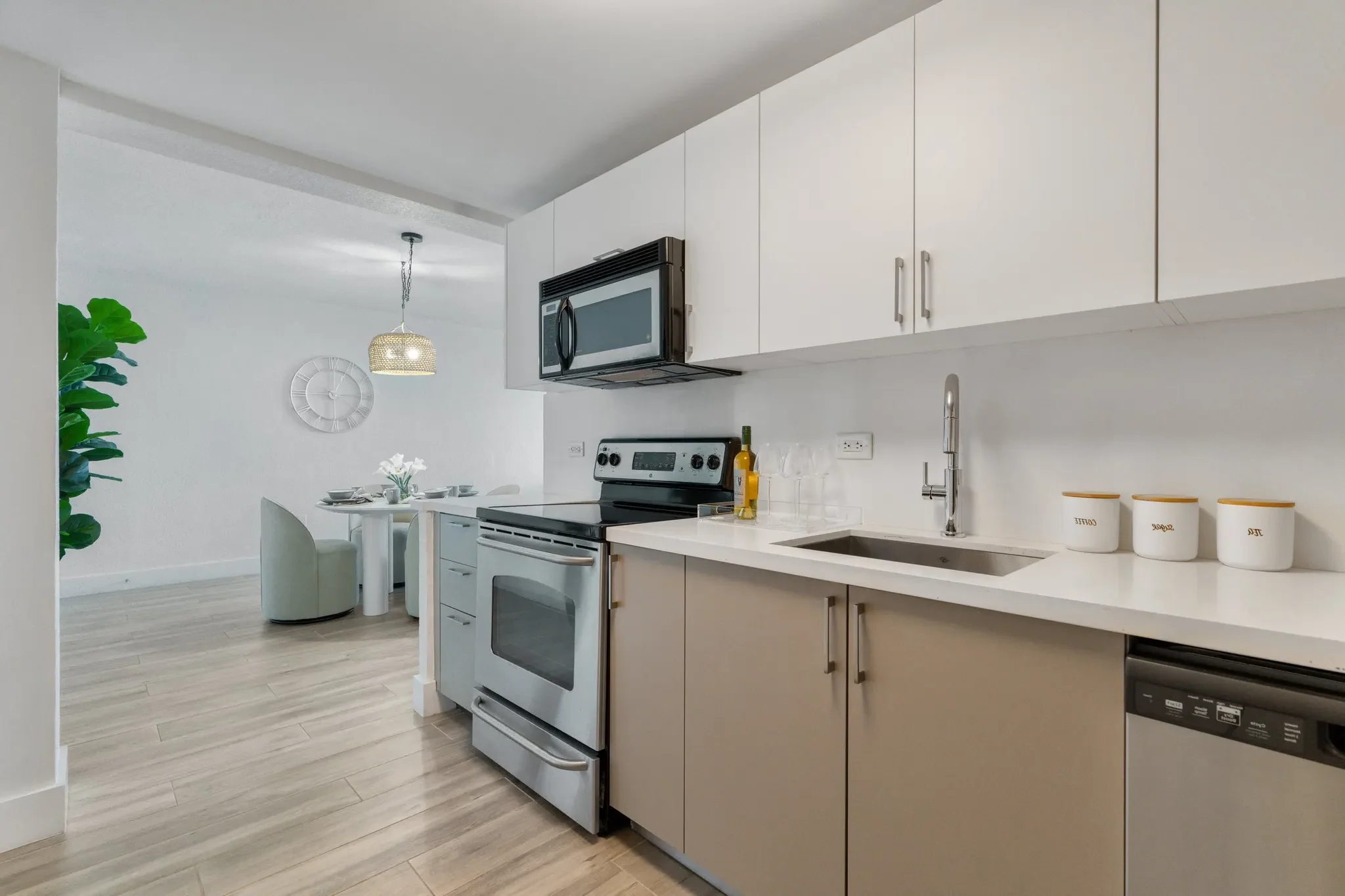 Modern Kitchen Design A modern kitchen featuring light cabinets, stainless steel appliances, and a sleek countertop. A dining area is visible in the background.