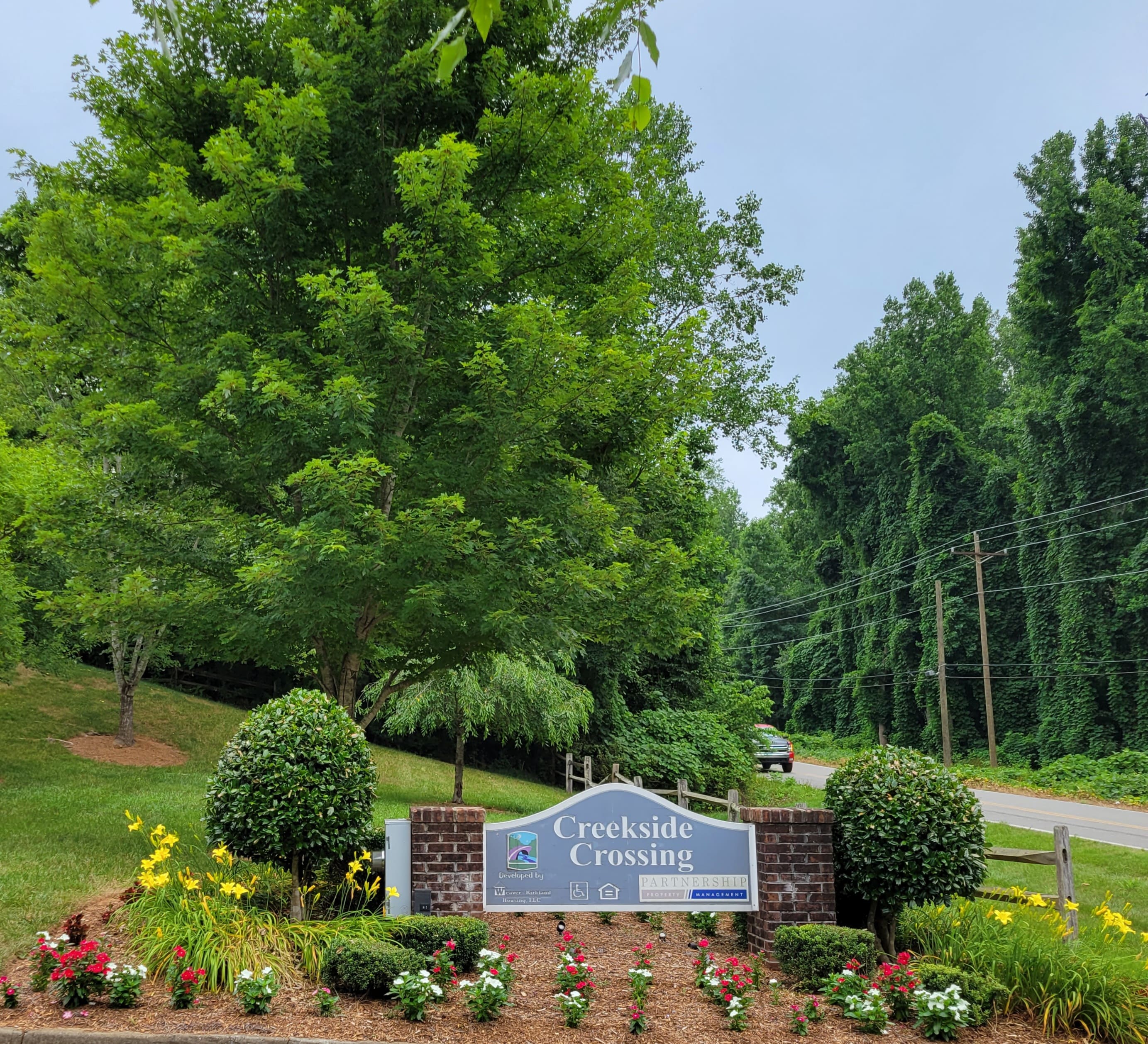 Creekside Crossing Entrance Sign for Creekside Crossing with landscaped flowers and greenery