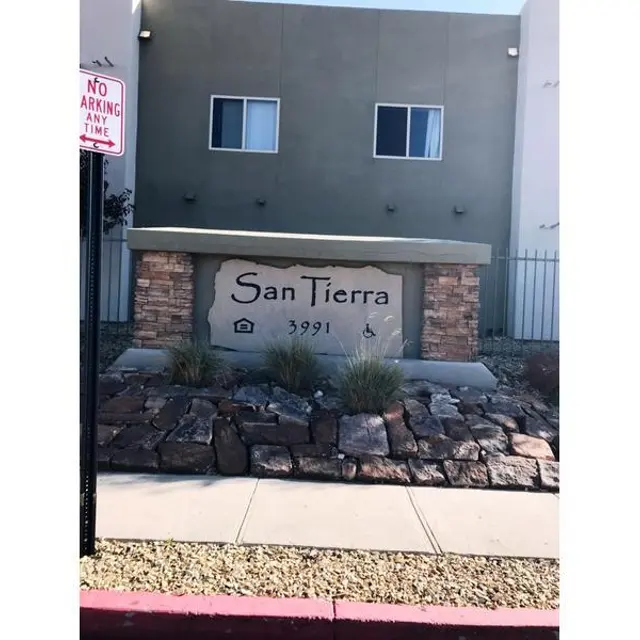Sign for San Tierra with a house symbol and the number 3991, located in front of a modern building.