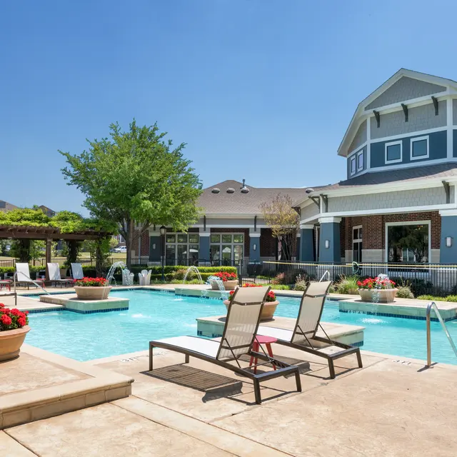 Centreport Lake Centreport Lake swimming pool featuring a selection of lounge chairs, red flowers, and a tree.