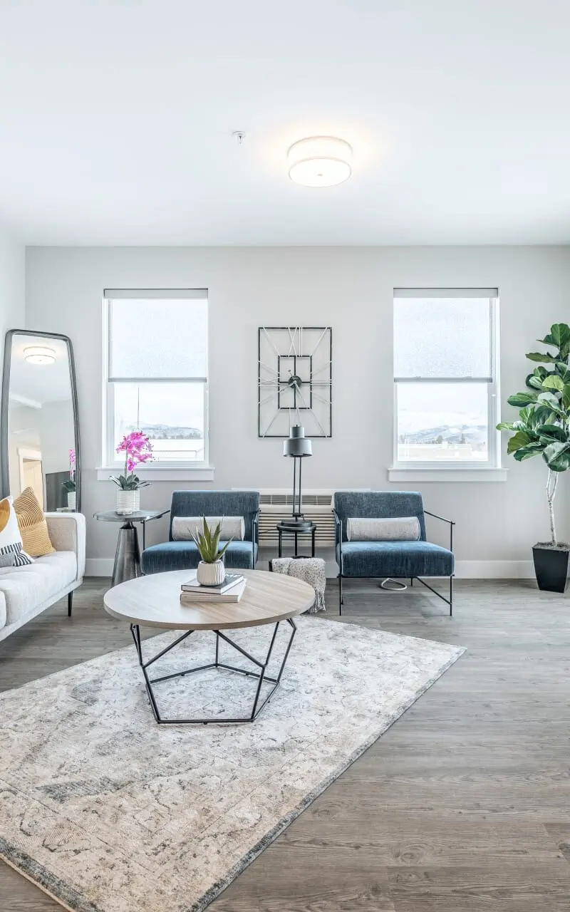 A spacious living room in the apartment, furnished with a couch, chairs, and elegant decor, offering a comfortable and inviting setting 