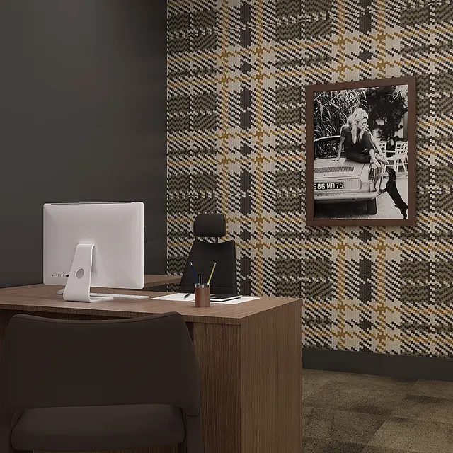 A modern office interior featuring a wooden desk with a computer, a chair, and decorative wall art. The wall is adorned with a plaid pattern wallpaper.