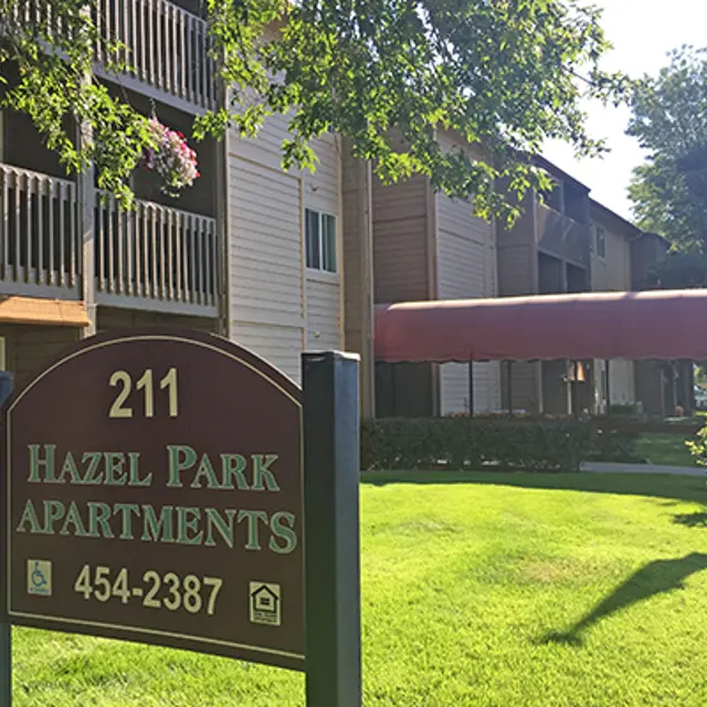 Exterior view of Hazel Park Apartments with a sign displaying the address and name.