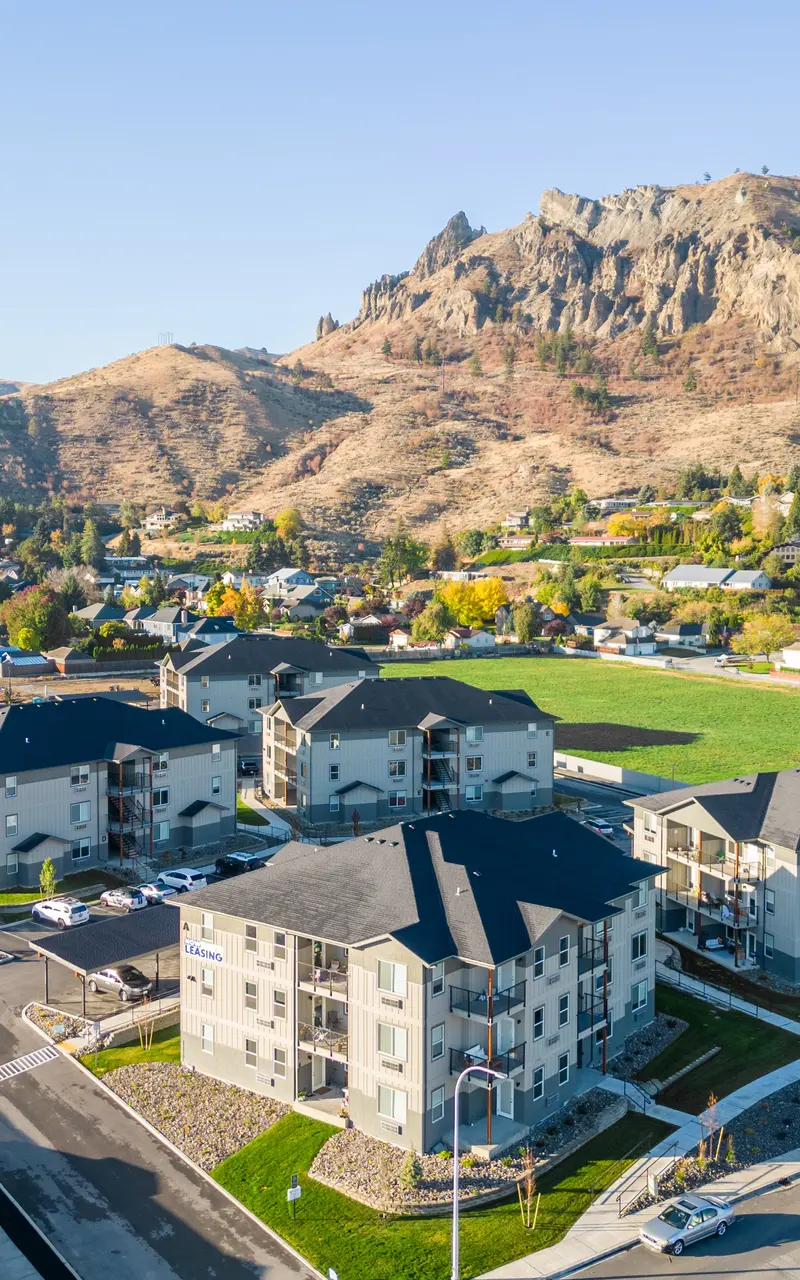 Aerial view of the Landing at Saddlerock apartment complex in Wenatchee, WA, showcasing its layout and surrounding environment, including mountains