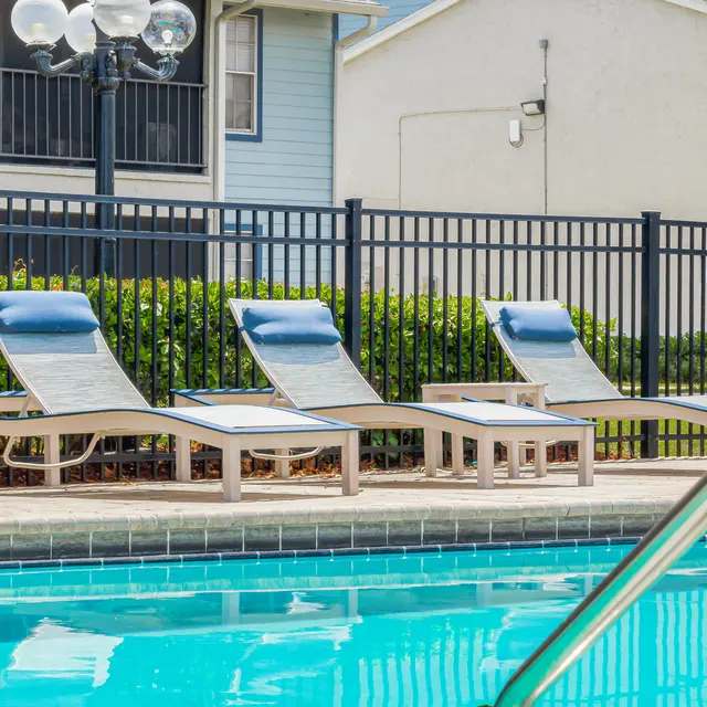 Gated resident pool with lounge chairs at Portofino Club Luxury Apartments