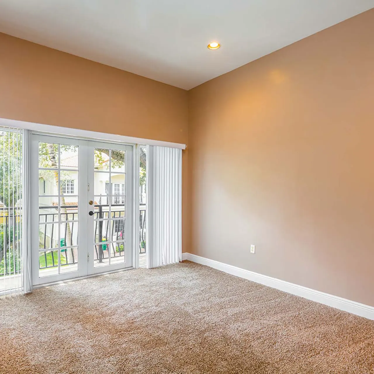 carpeted room with attached balcony