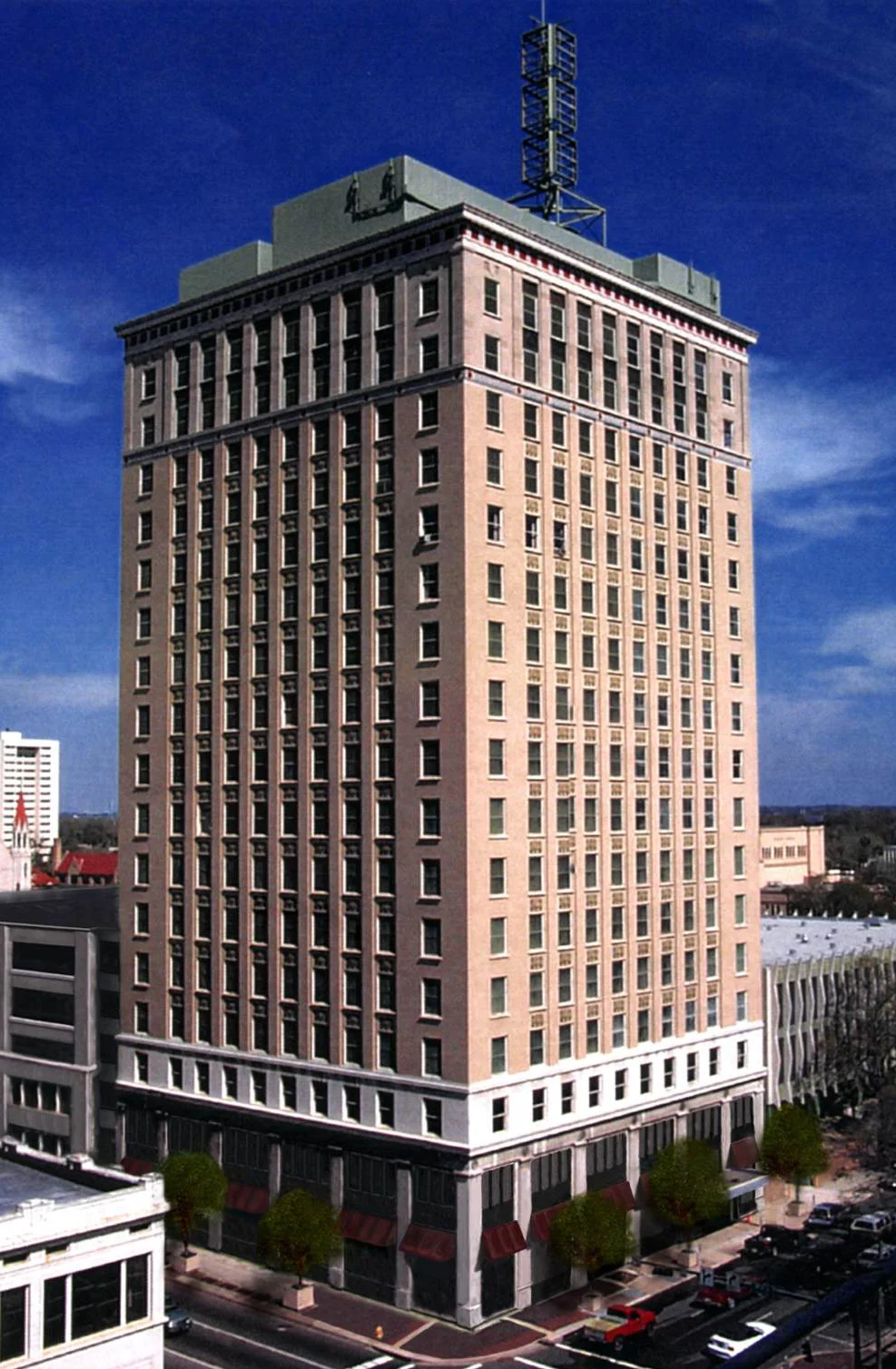 A historic multi-story building with a classic architectural design, featuring windows and decorative elements on the facade, set against a blue sky.