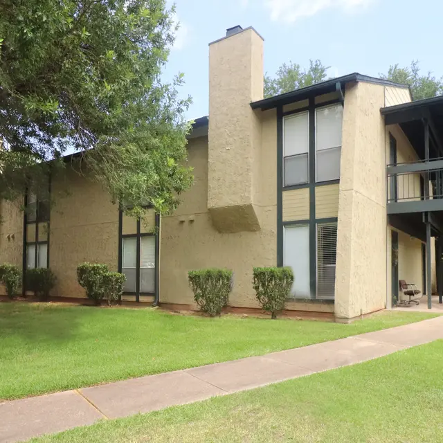 Two-Story Apartment Complex Exterior view of a two-story apartment complex surrounded by well-maintained lawns and shrubs.