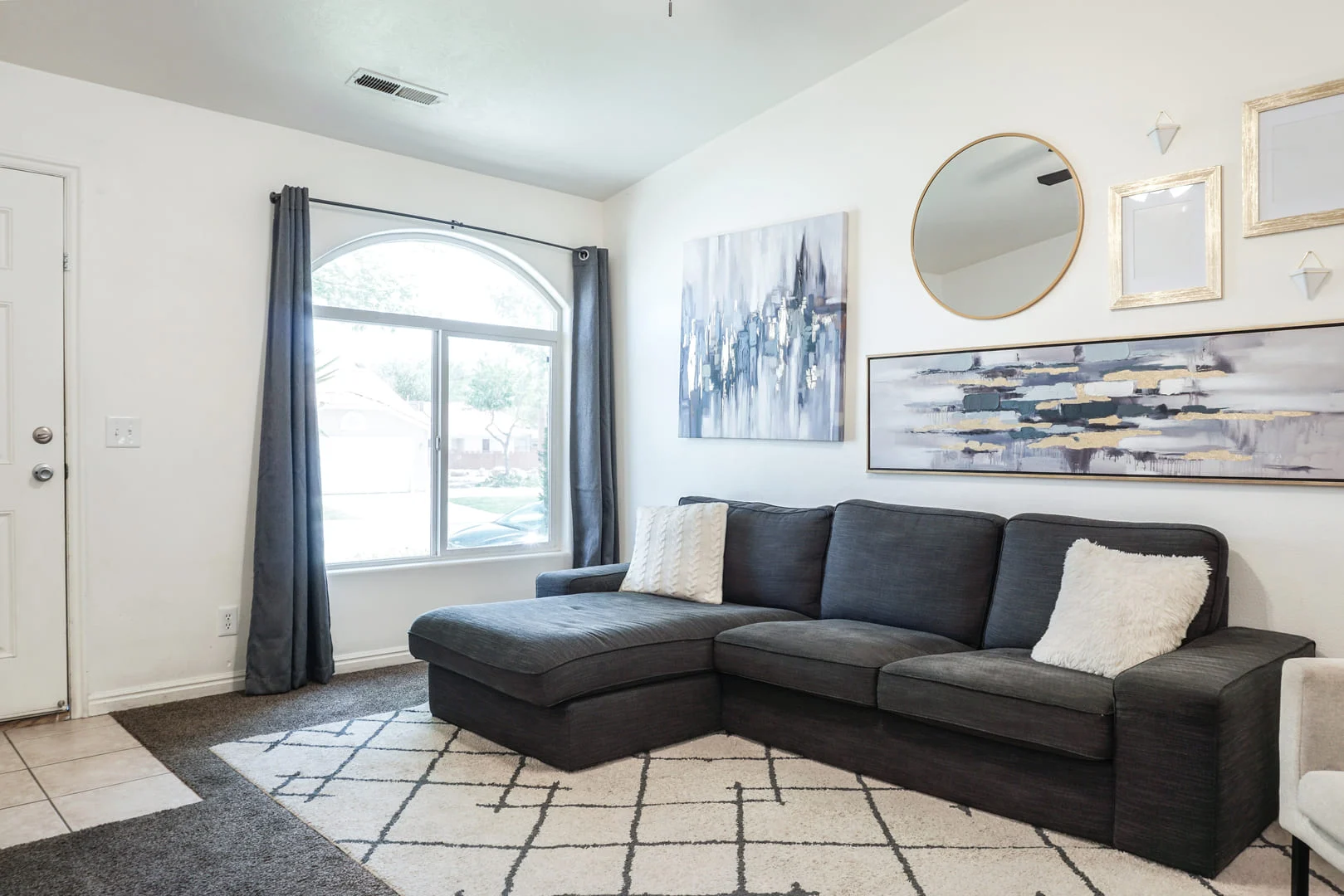 Cozy living room with a modern sofa, large window, and contemporary wall art.