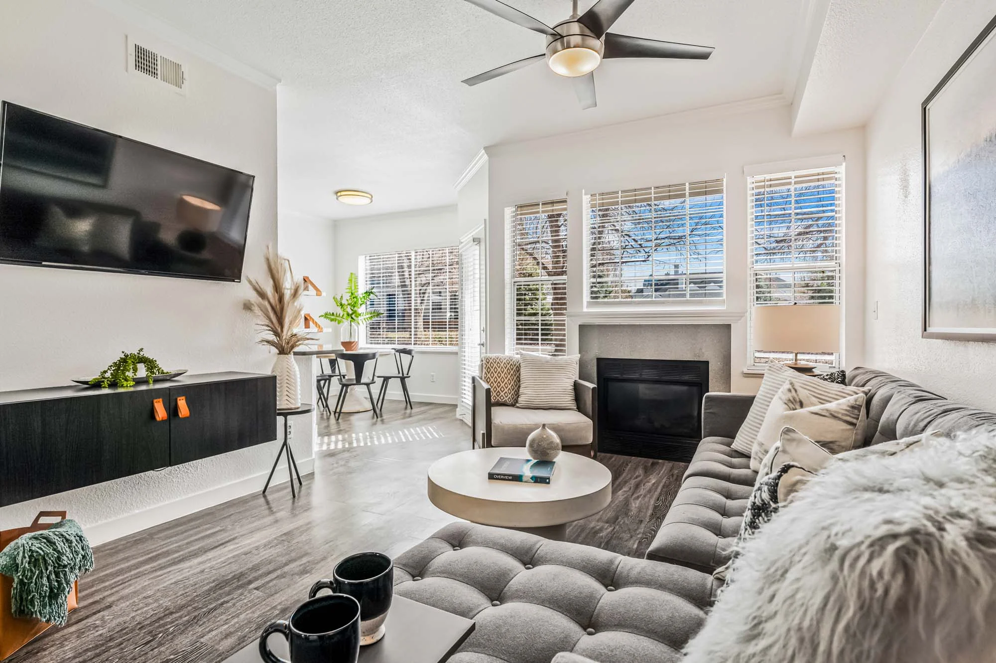 Contemporary Living Room Design A modern living room with a cozy sofa, decorative cushions, a round coffee table, and a television mounted on the wall.