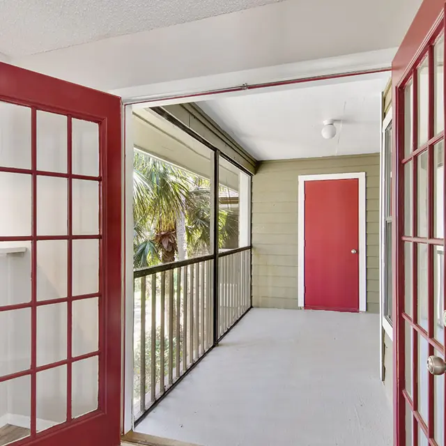 Venice Park french doors opening to a balcony facing a red door.