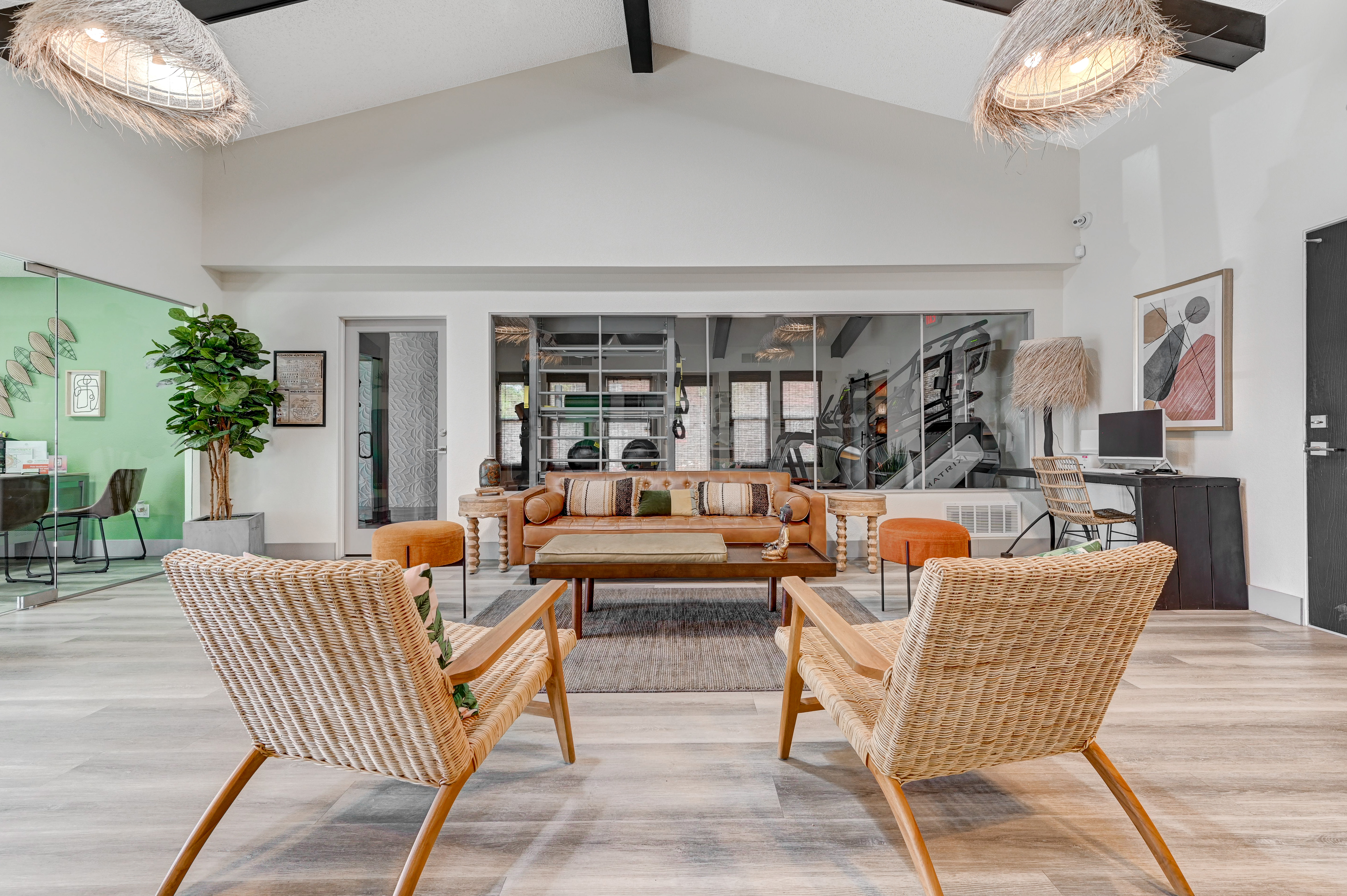A modern communal living area with a high ceiling, featuring comfortable seating, a coffee table, and decorative elements.