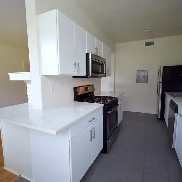 A modern kitchen featuring white cabinetry, stainless steel appliances, and a sleek countertop.