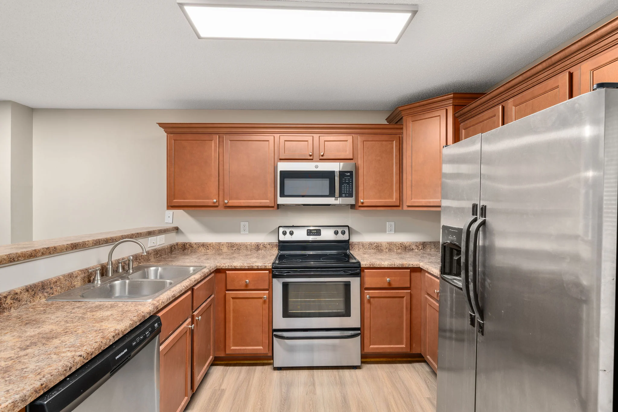 Modern Kitchen Design A modern kitchen featuring wooden cabinets, stainless steel appliances, and a granite countertop.