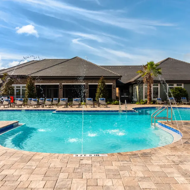 large resort style pool with lounge chairs and palm trees hanging over