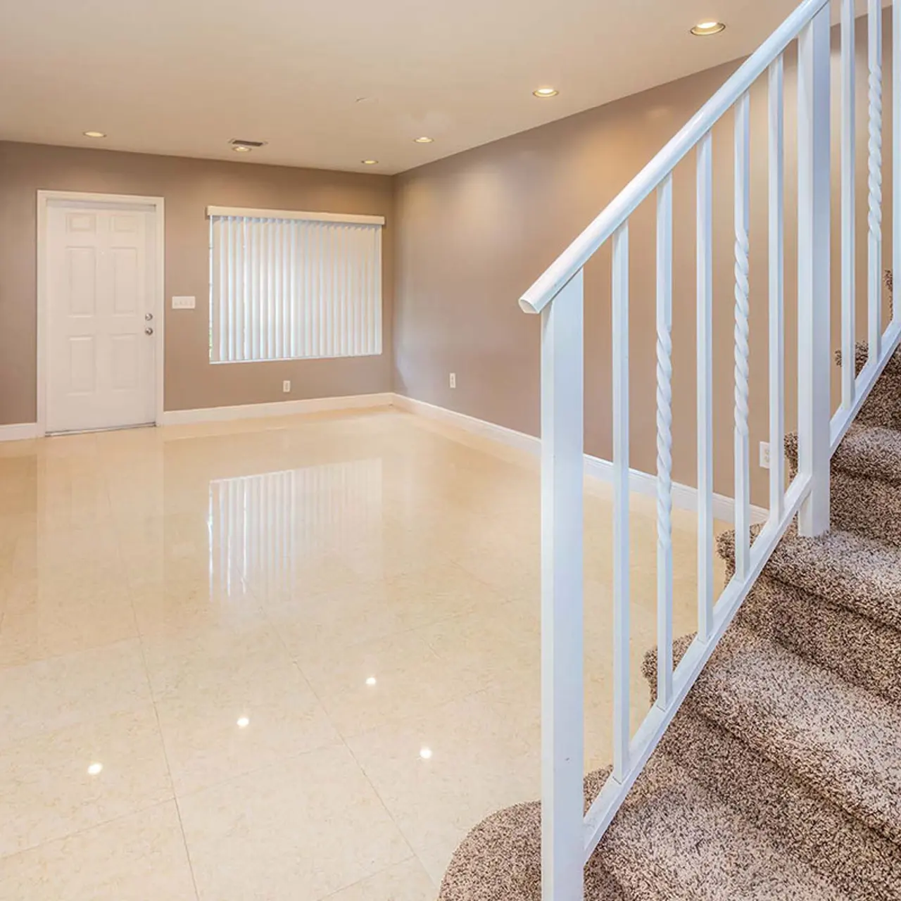 tile floored living room with carpeted stairs leading you to the second floor
