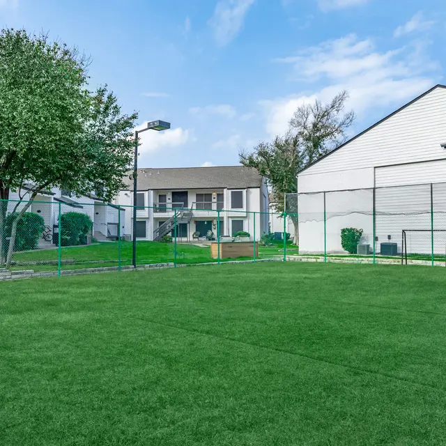 Fenced-in grass area in the dog park at Aviva at North Plaza.