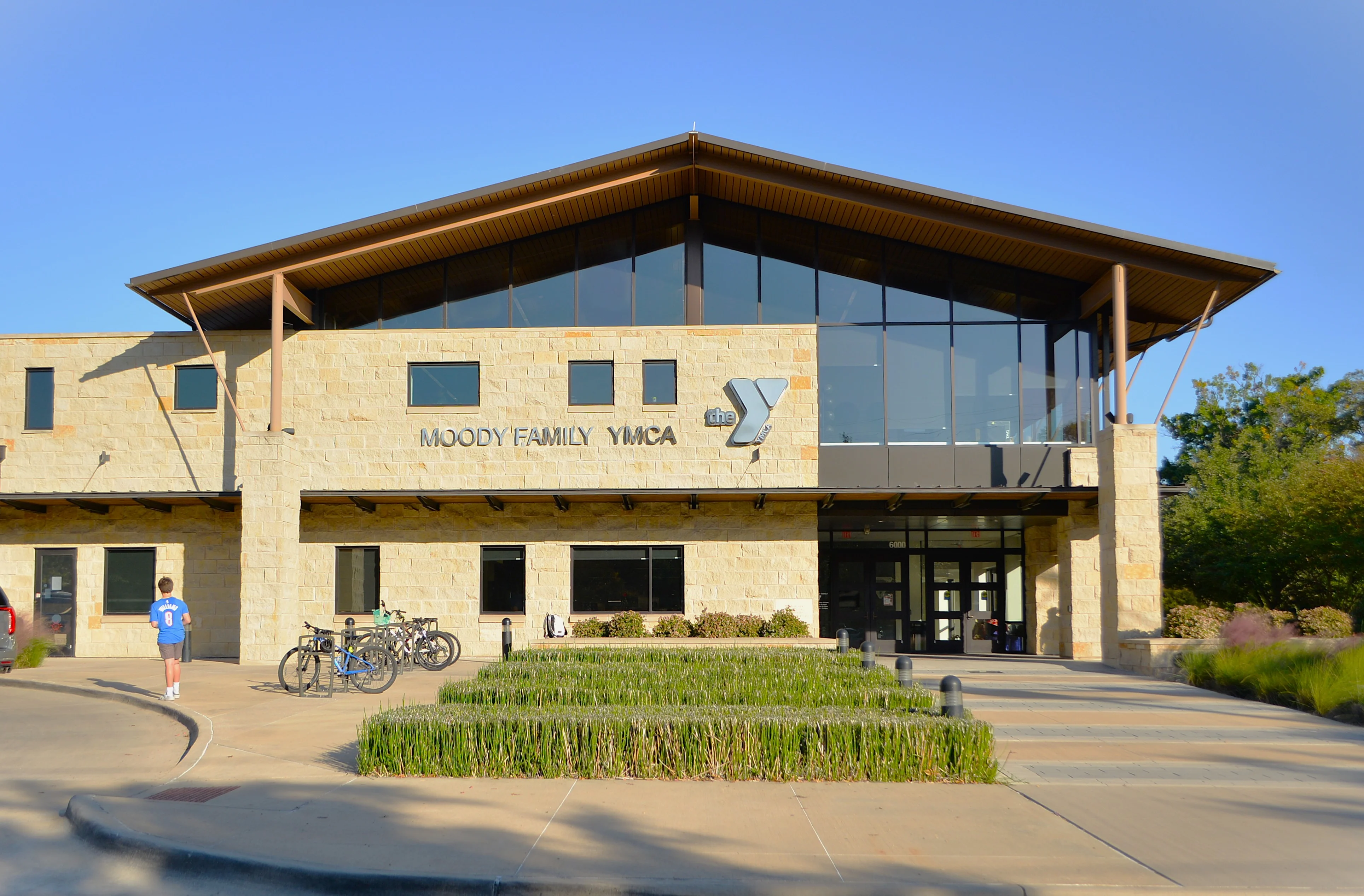 Moody Family YMCA Building Exterior view of the Moody Family YMCA building featuring large glass windows and a modern architectural design.