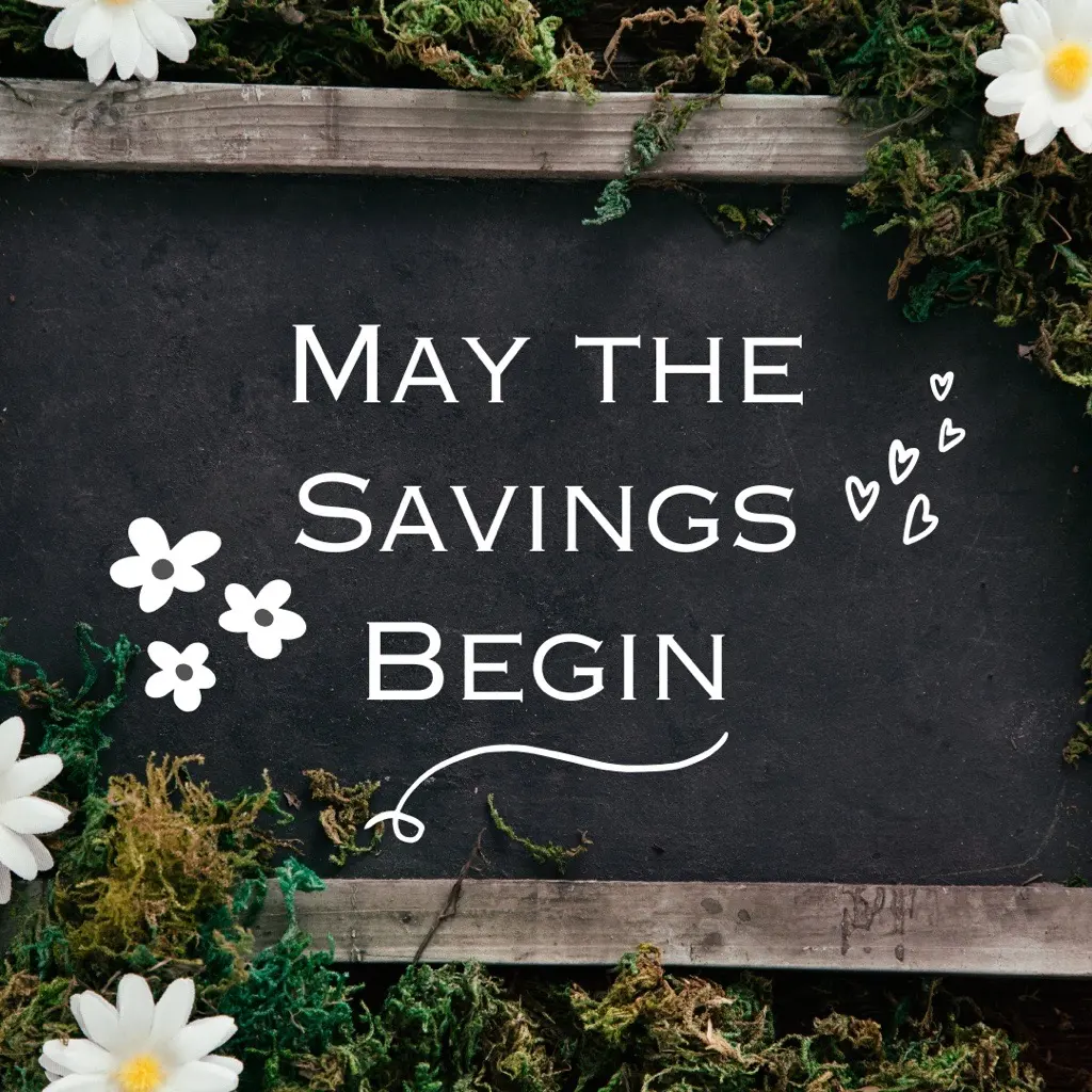 Savings Announcement A decorative chalkboard with the text 'May the Savings Begin' surrounded by greenery and white flowers.
