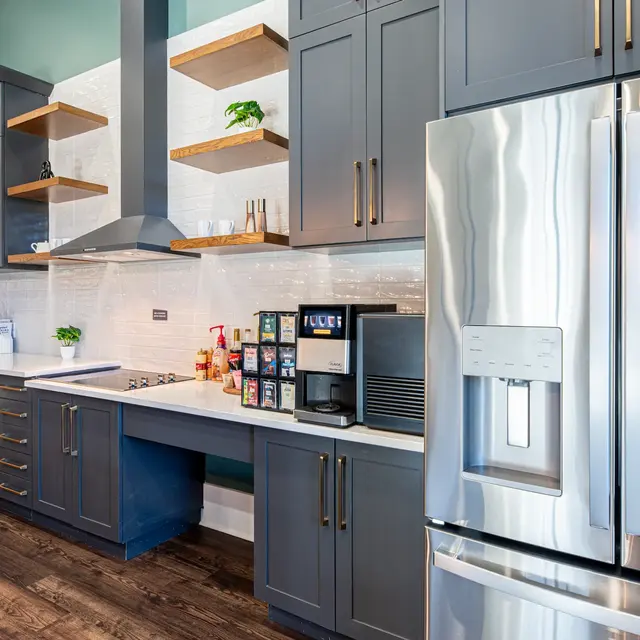Modern kitchen featuring dark cabinetry, stainless steel appliances, and open shelving.