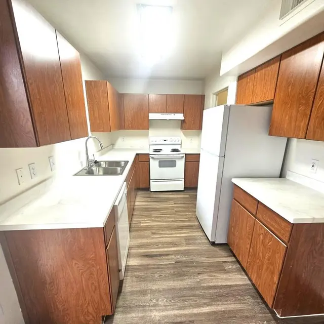 Bright and Modern Kitchen Design A modern kitchen featuring wooden cabinets, a white stove, and a refrigerator with a white countertop and wooden floor.