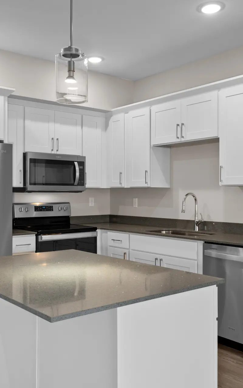 Modern kitchen in an apartment with stainless steel appliances and stylish finishes with a central island, large countertop, built-in sink, providing a functional and stylish workspace