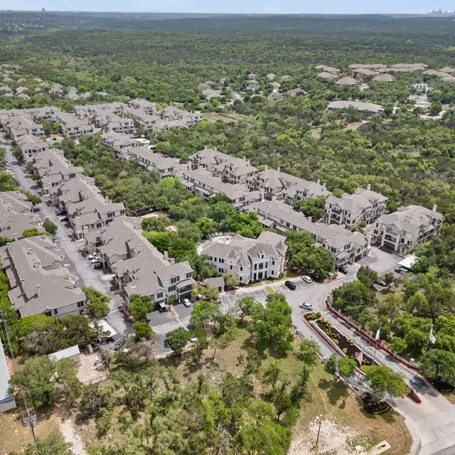 Aerial view of a residential apartment complex surrounded by lush greenery.