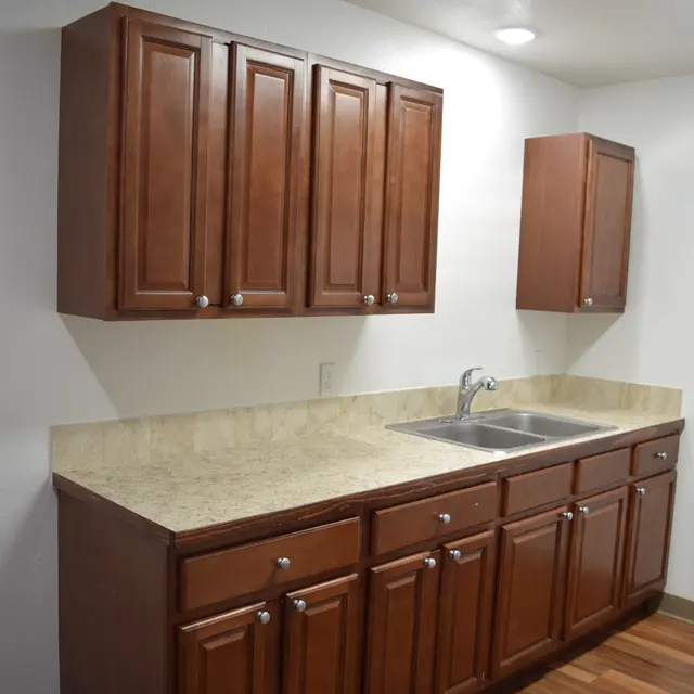 Modern Kitchen Design A modern kitchen featuring brown wooden cabinets and a beige countertop with a sink.