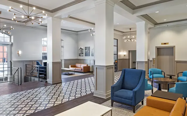 A spacious modern lobby area featuring stylish seating and decorative lighting.