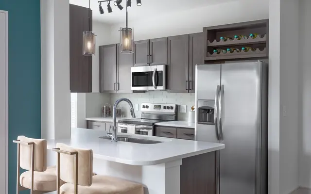 fully equipped kitchen area with 2 bar chairs, a white tile
backsplash and wines - Room, Indoors, Refrigerator