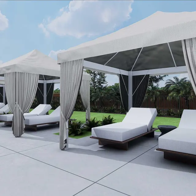 Luxurious cabanas with white curtains and sun loungers, set by a serene poolside surrounded by greenery under a blue sky.