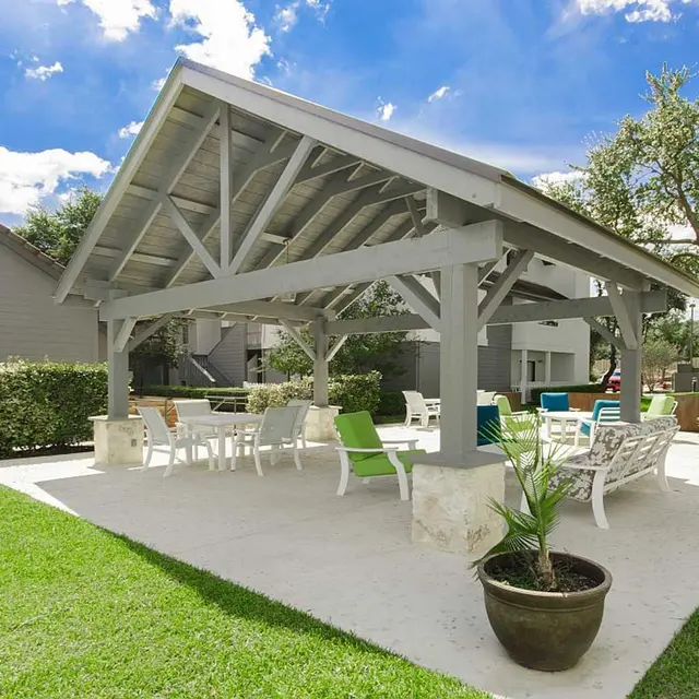 Covered outdoor seating area with patio table and chairs and cushioned patio chairs in San Antonio, TX