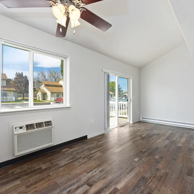 Modern Living Room Interior Spacious living room with a ceiling fan, large windows, and hardwood flooring.