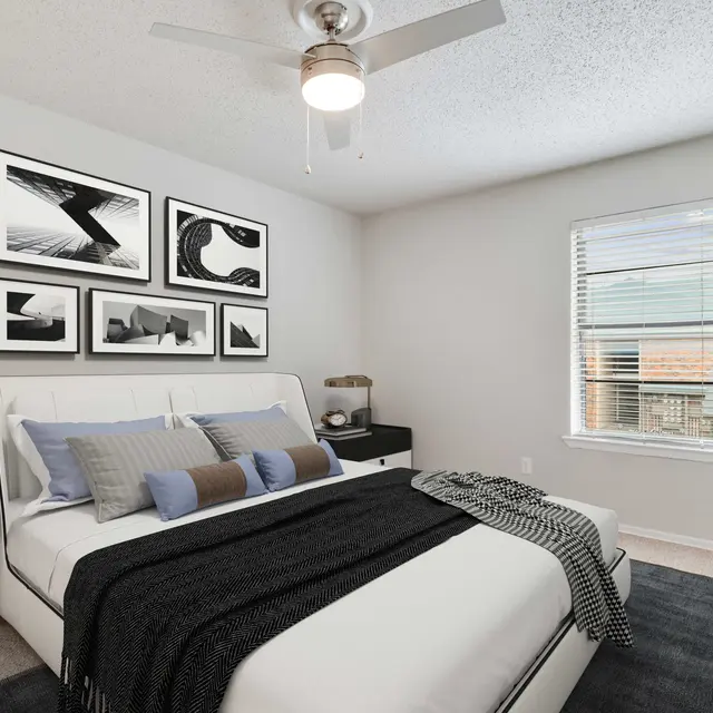 Carpeted bedroom with ceiling fan and overhead light in Dallas, TX apartments