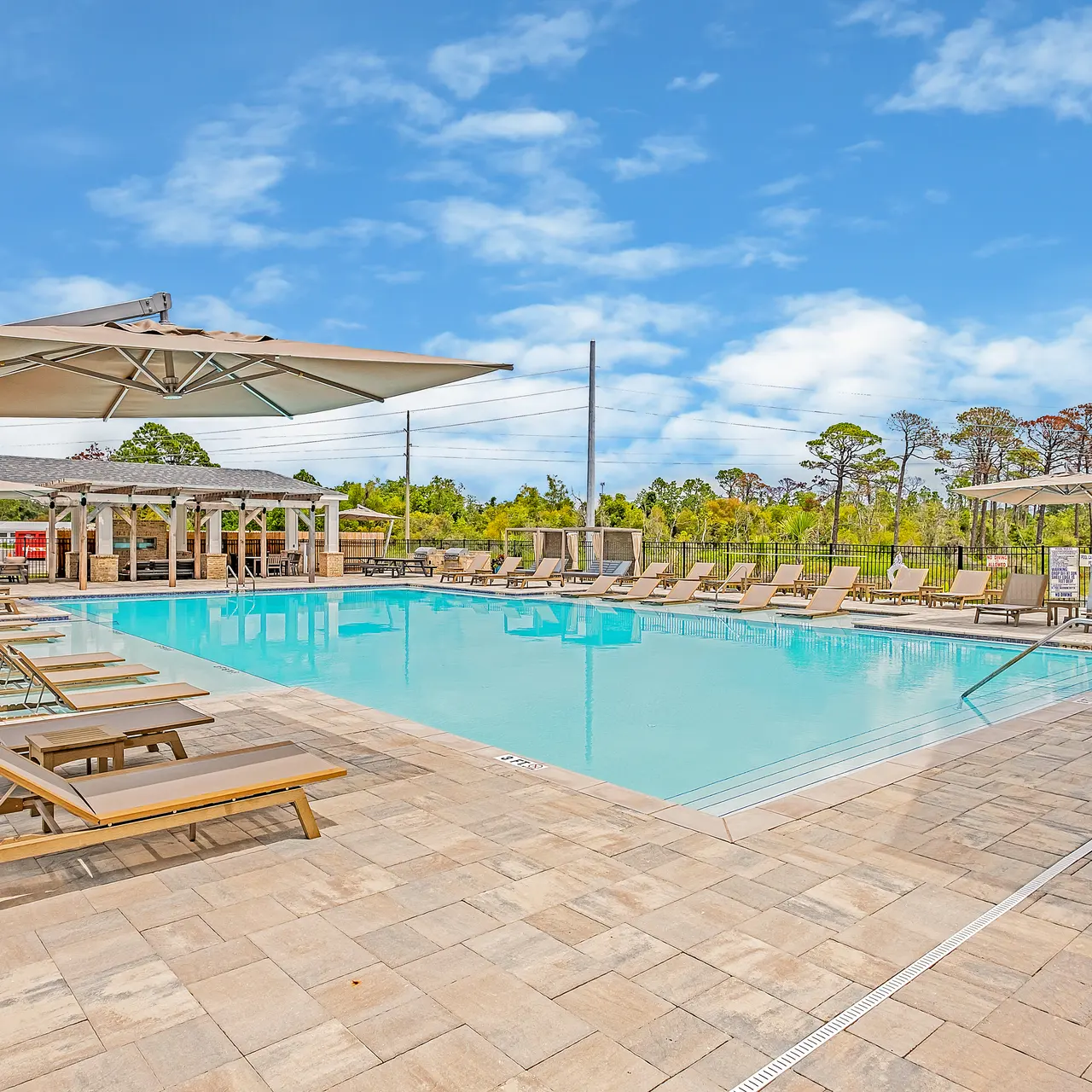 large swimming pool with lounge seating all around