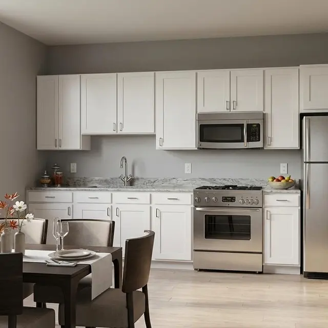 A modern kitchen with white cabinets and stainless steel appliances, featuring a dining table for four.