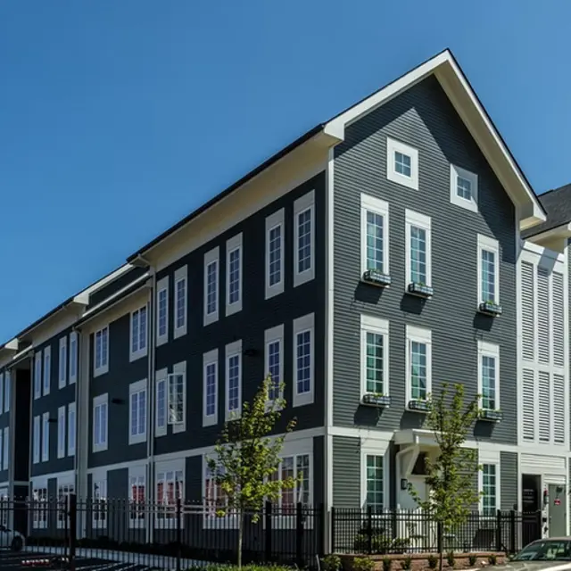 Modern Architectural Building Modern three-story building with a gray exterior and white trim on a clear day.