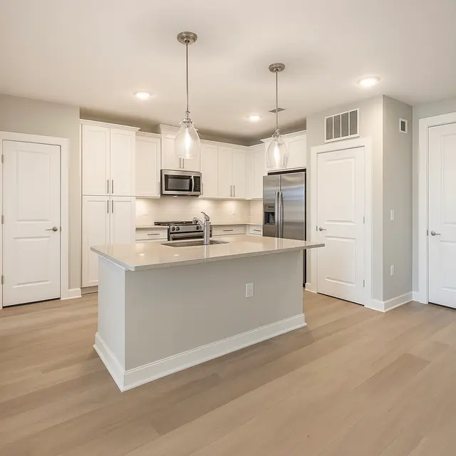 Modern Kitchen Interior A modern kitchen featuring a central island, stainless steel appliances, and white cabinetry with light wood flooring.