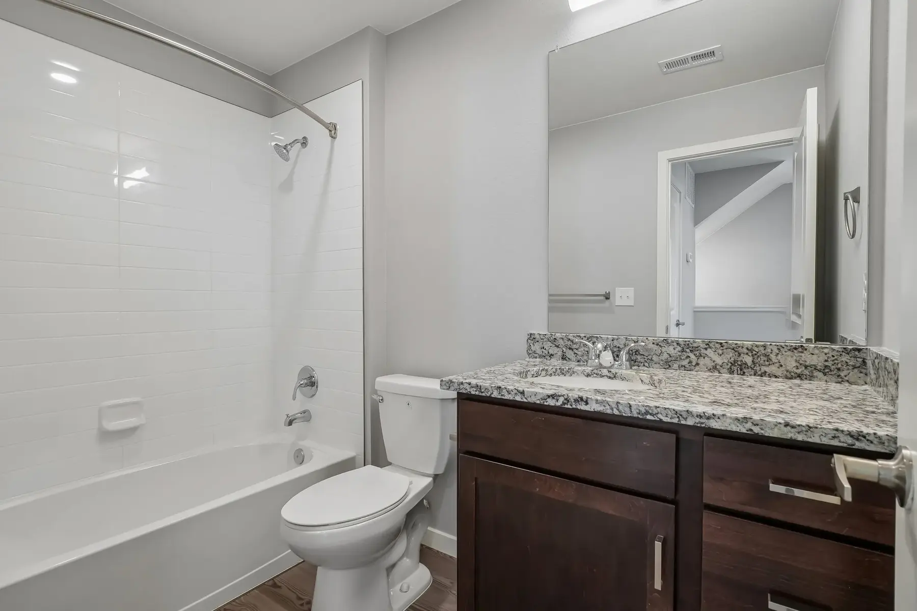 Modern Bathroom Interior A modern bathroom with a bathtub, toilet, and vanity featuring a granite countertop.