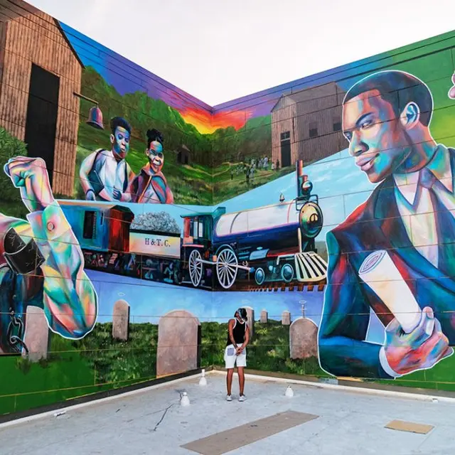 A colorful mural featuring two male figures, a train, and multiple people in a vibrant urban setting.