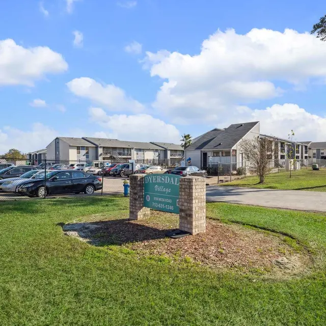 Sign for Diversdal College in front of an apartment complex on a sunny day.
