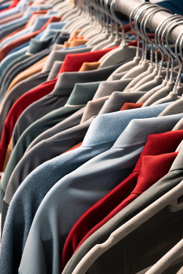 Colorful Shirts on Display A close-up of a clothing rack displaying various shirts hanging in rows, showcasing a variety of colors and patterns.