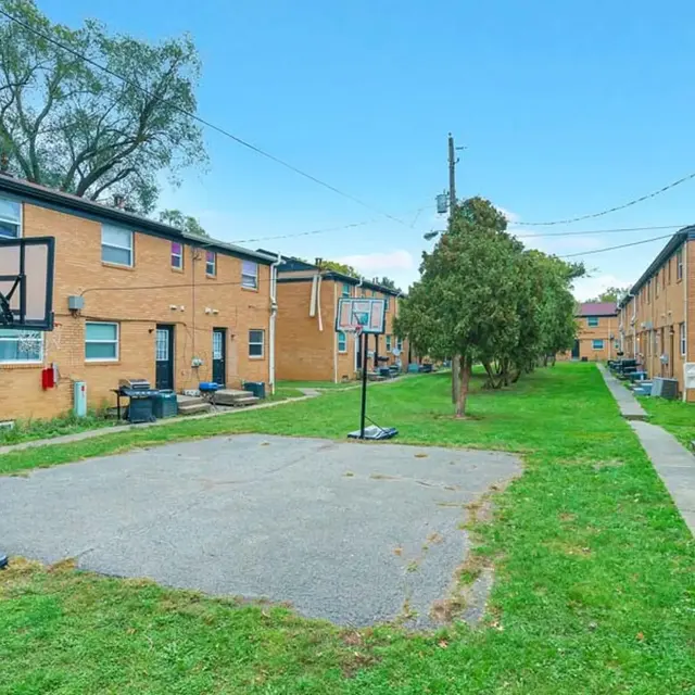 View of a basketball court surrounded by apartment buildings.
